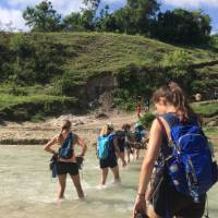 Fording a river on the way to a waterfall near Verrettes, Haiti